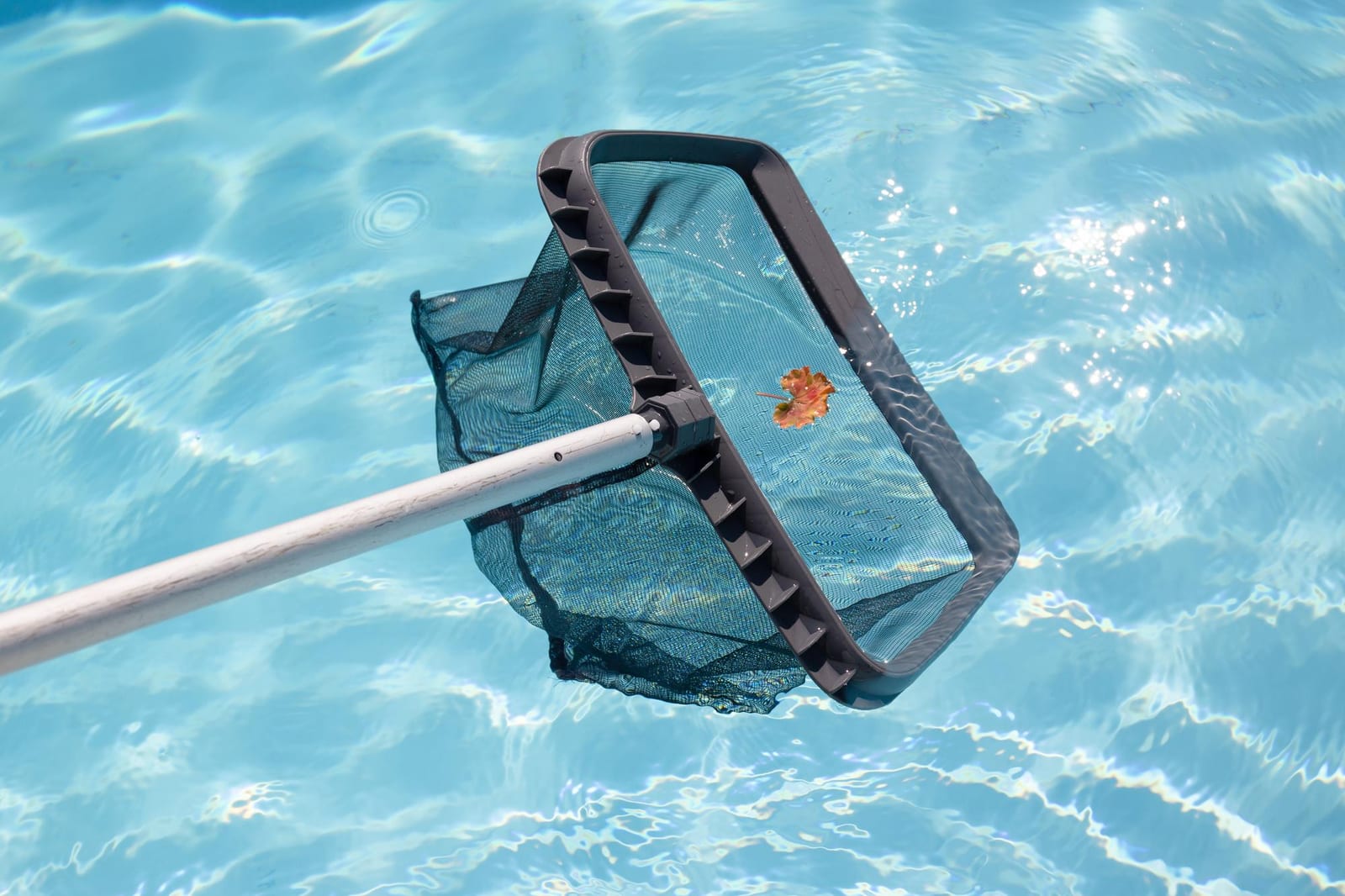 Inground pool shell being installed into an excavated backyard site