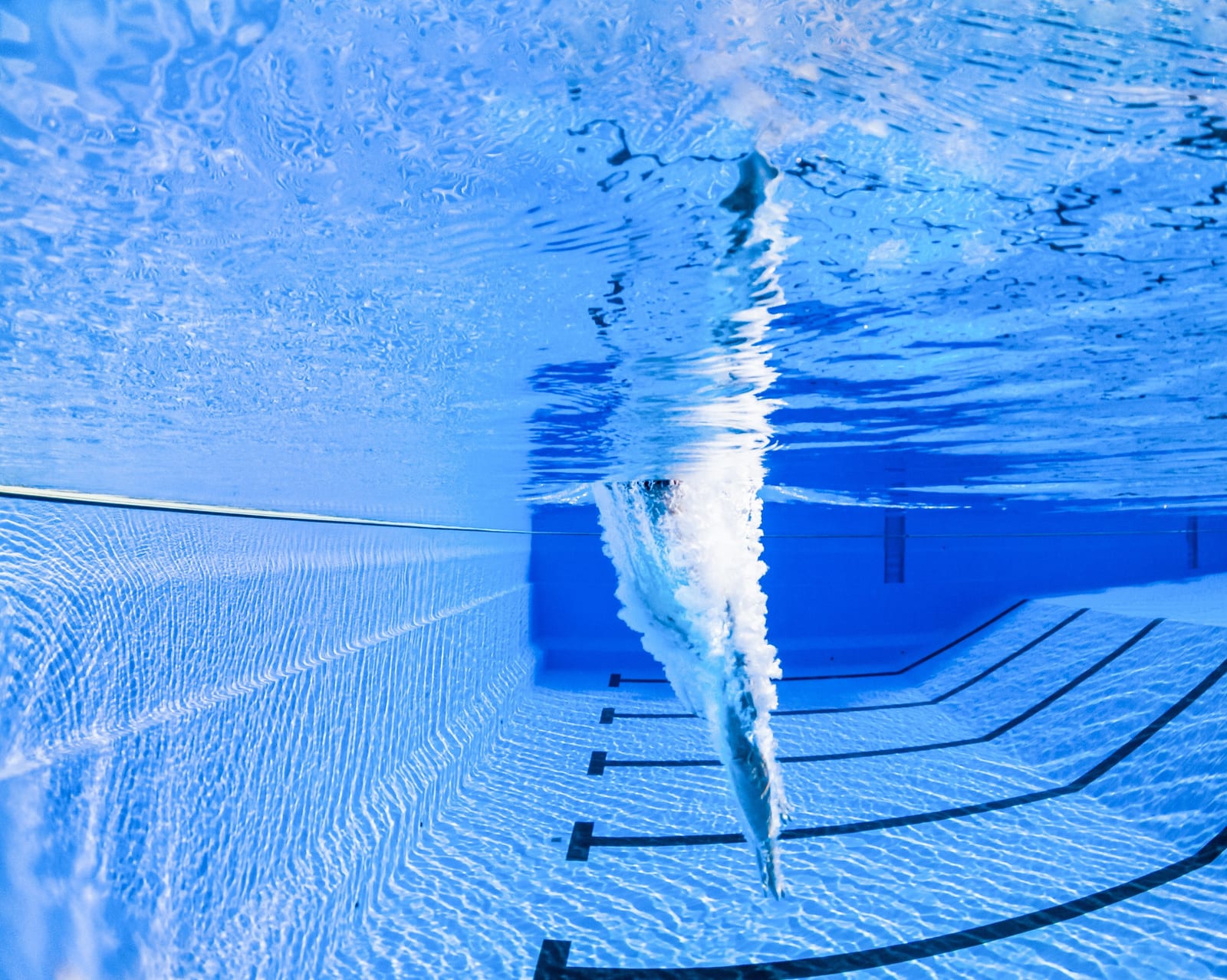 Diving board mounted at the deep end of an inground pool